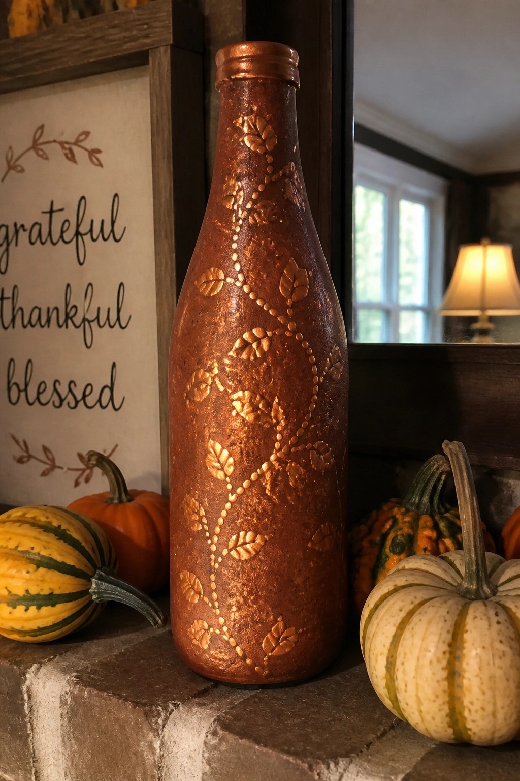 Rustic copper bottle with embossed leaves beside colorful pumpkins and grateful thankful blessed sign.