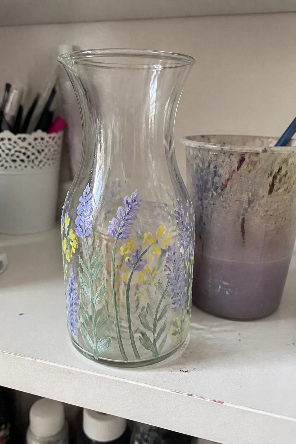 Glass vase hand-painted with purple lavender and yellow flowers on white shelf