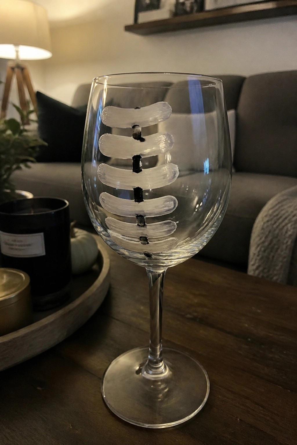 Clear wine glass with white horizontal strokes and black dots like a snowman