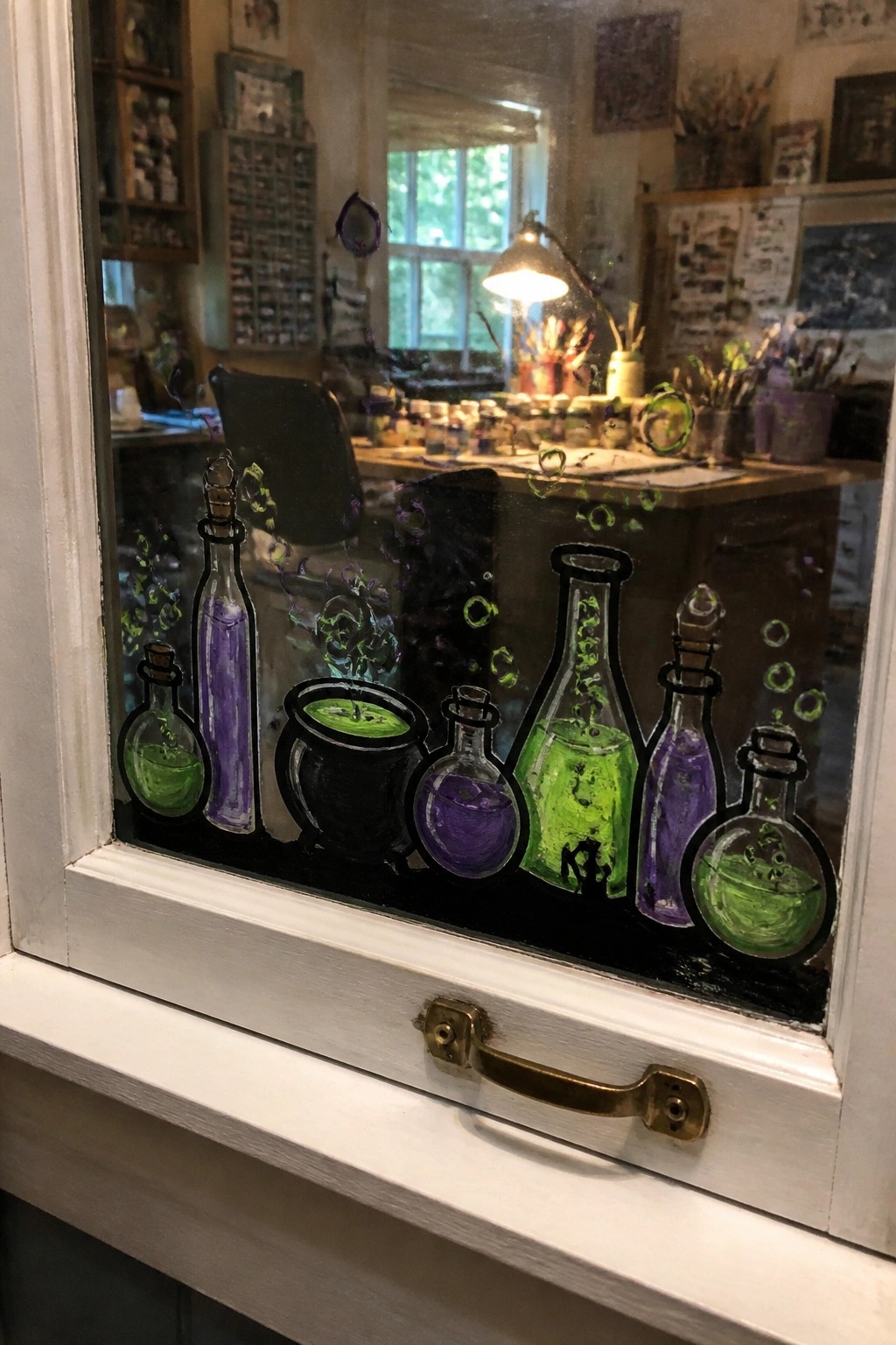 Vibrant potion bottles and cauldron painted on glass overlooking art studio