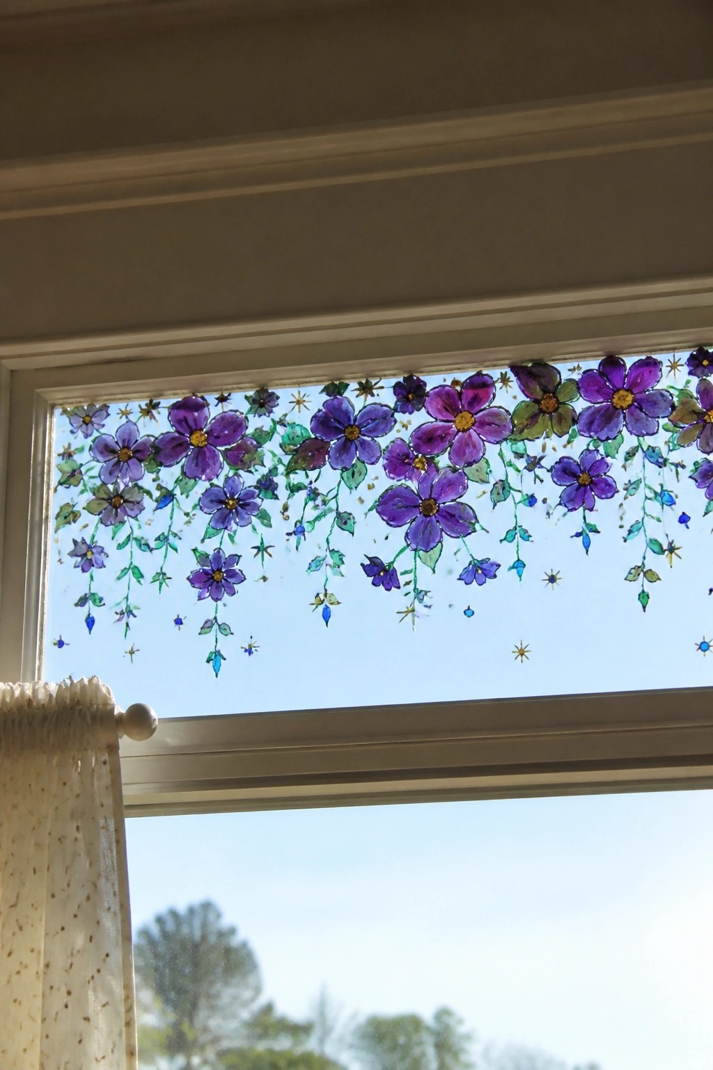 Window decorated with purple flowers, green vines, and gold stars