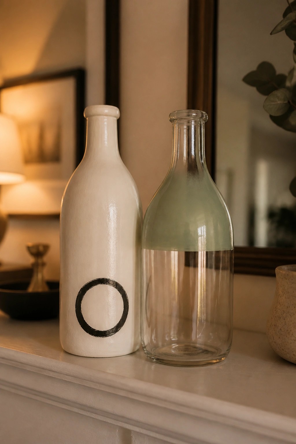 White bottle with black circle beside clear glass bottle with green top