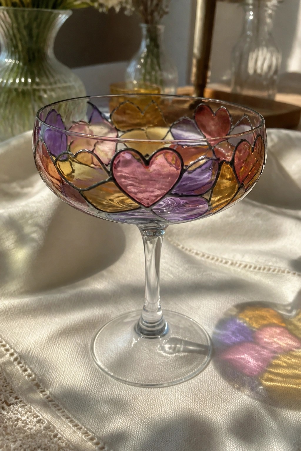 Stained glass coupe with vibrant multicolored hearts on white fabric with shadow