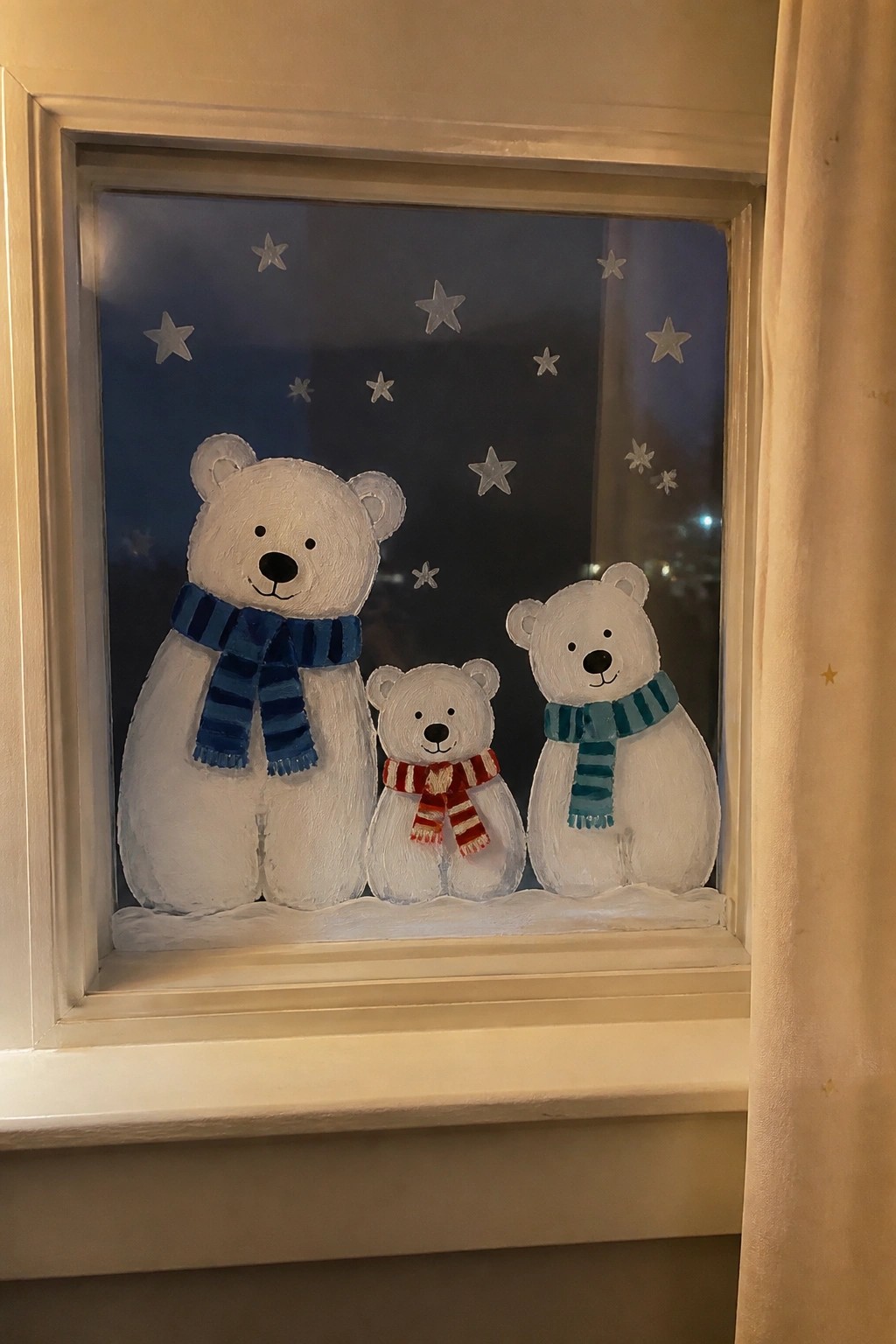 Three painted polar bears with striped scarves on snowy windowsill with stars.