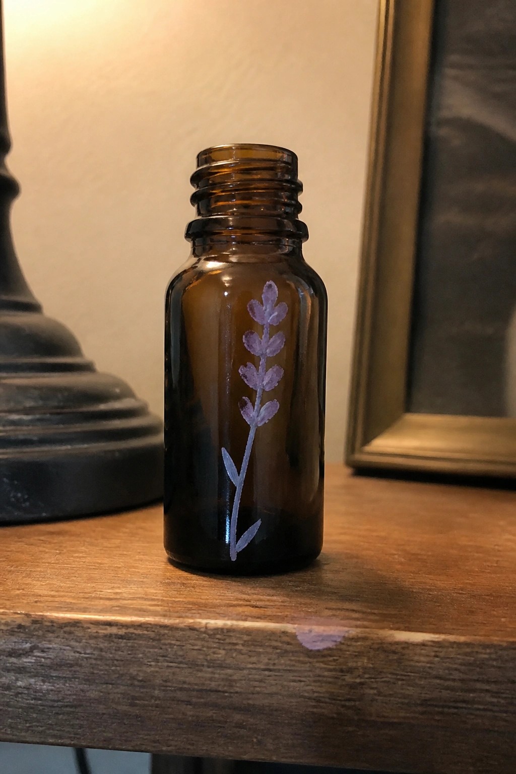 Small brown glass bottle with hand-painted purple lavender on wooden table