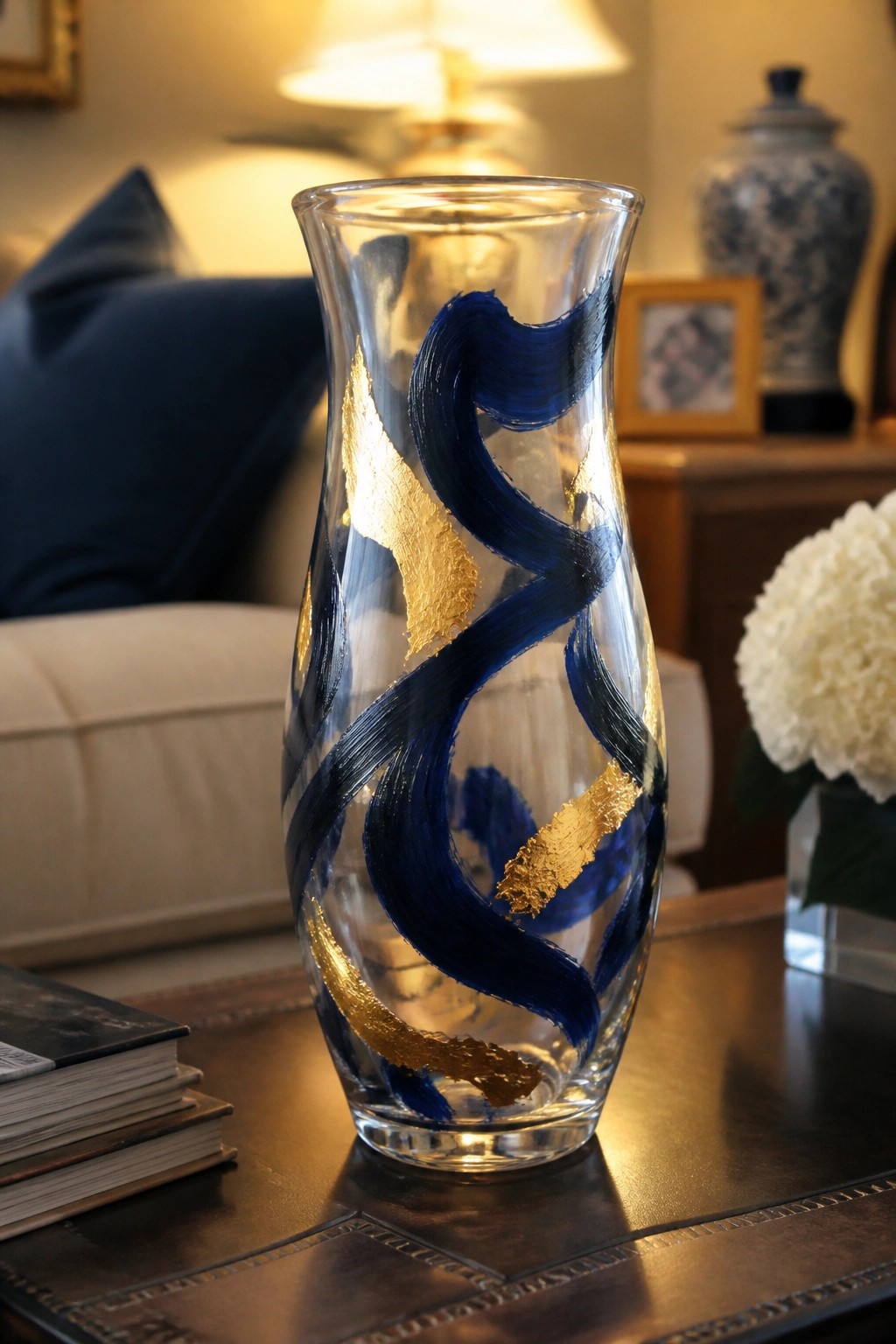 Glass vase with swirling blue and gold brushstrokes on wooden table