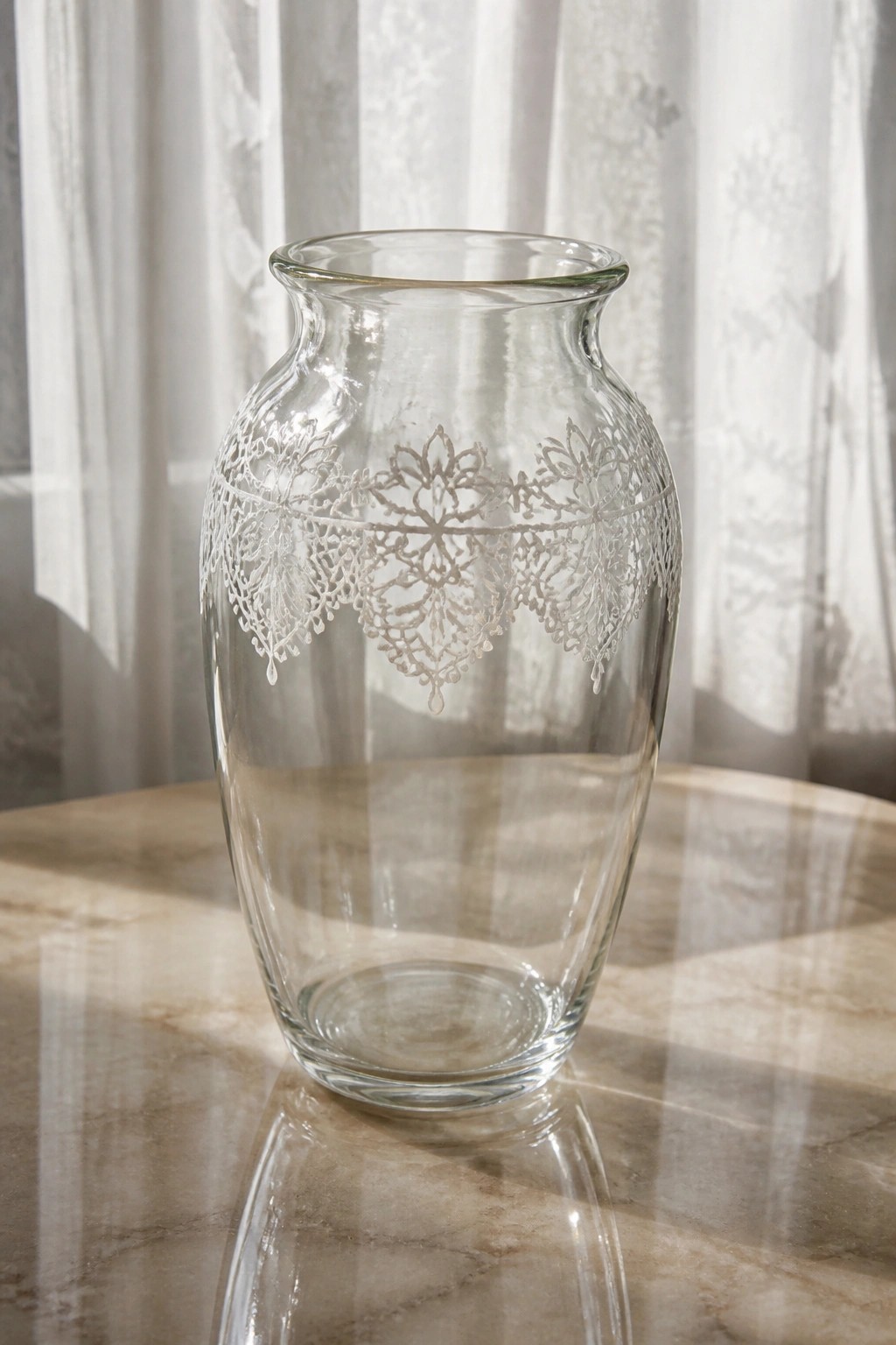 Clear glass vase with intricate etched lace pattern on marble table