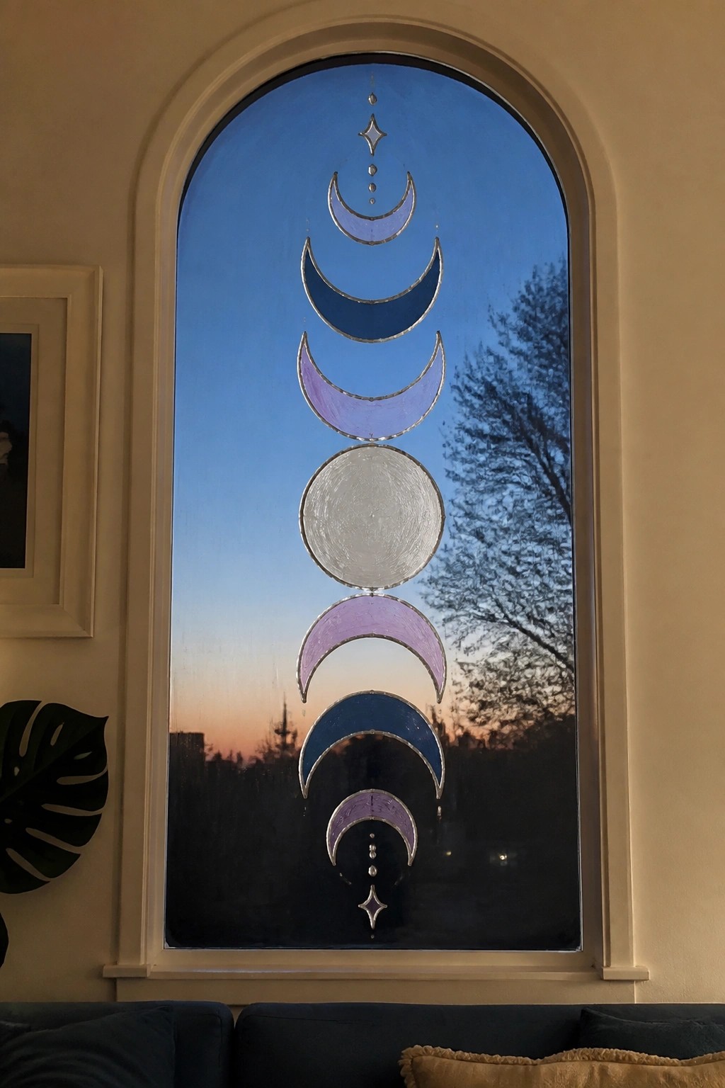 Arched window with vertical moon phases in purple and blue stained glass