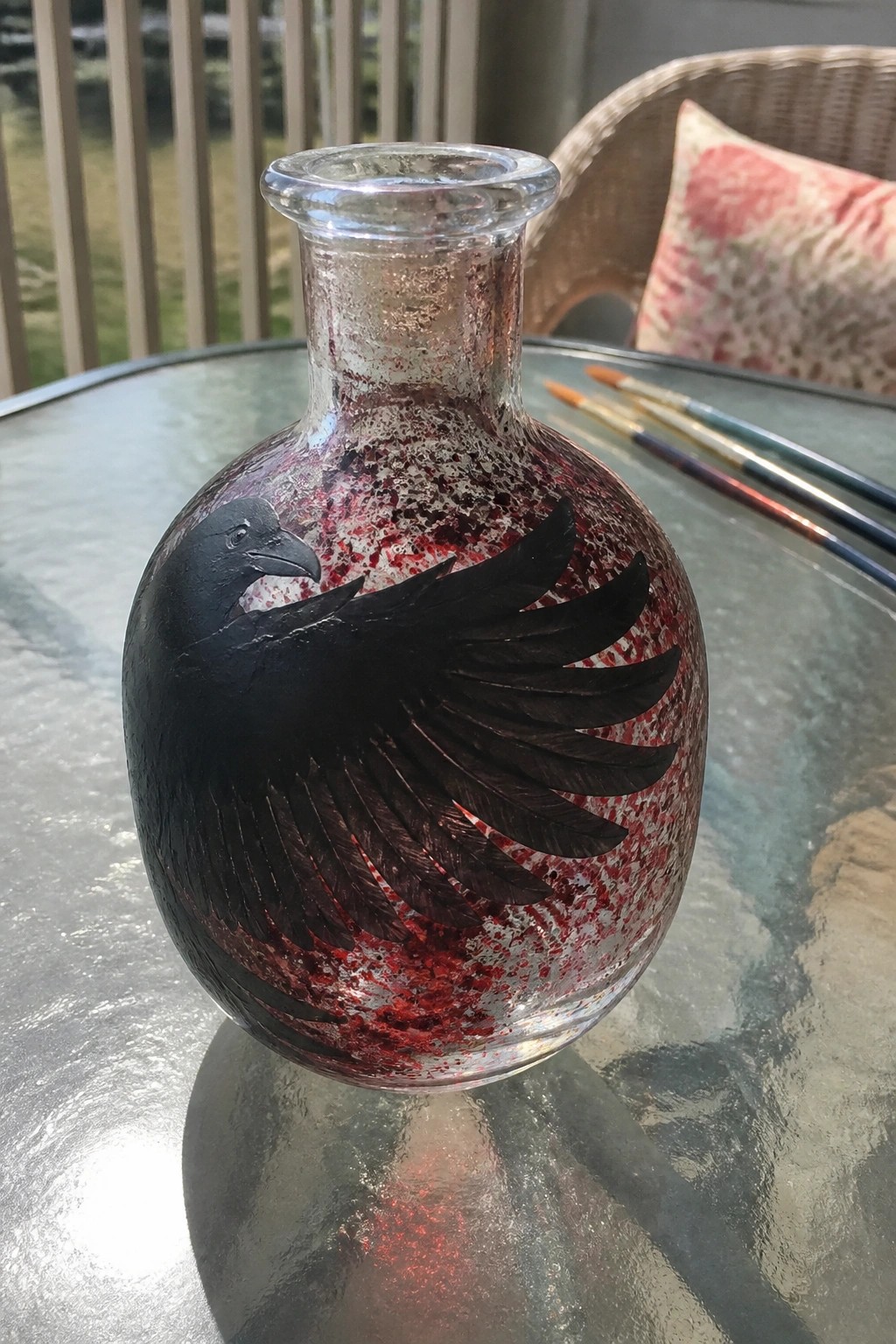 Red and silver speckled glass vase with black bird spreading wings