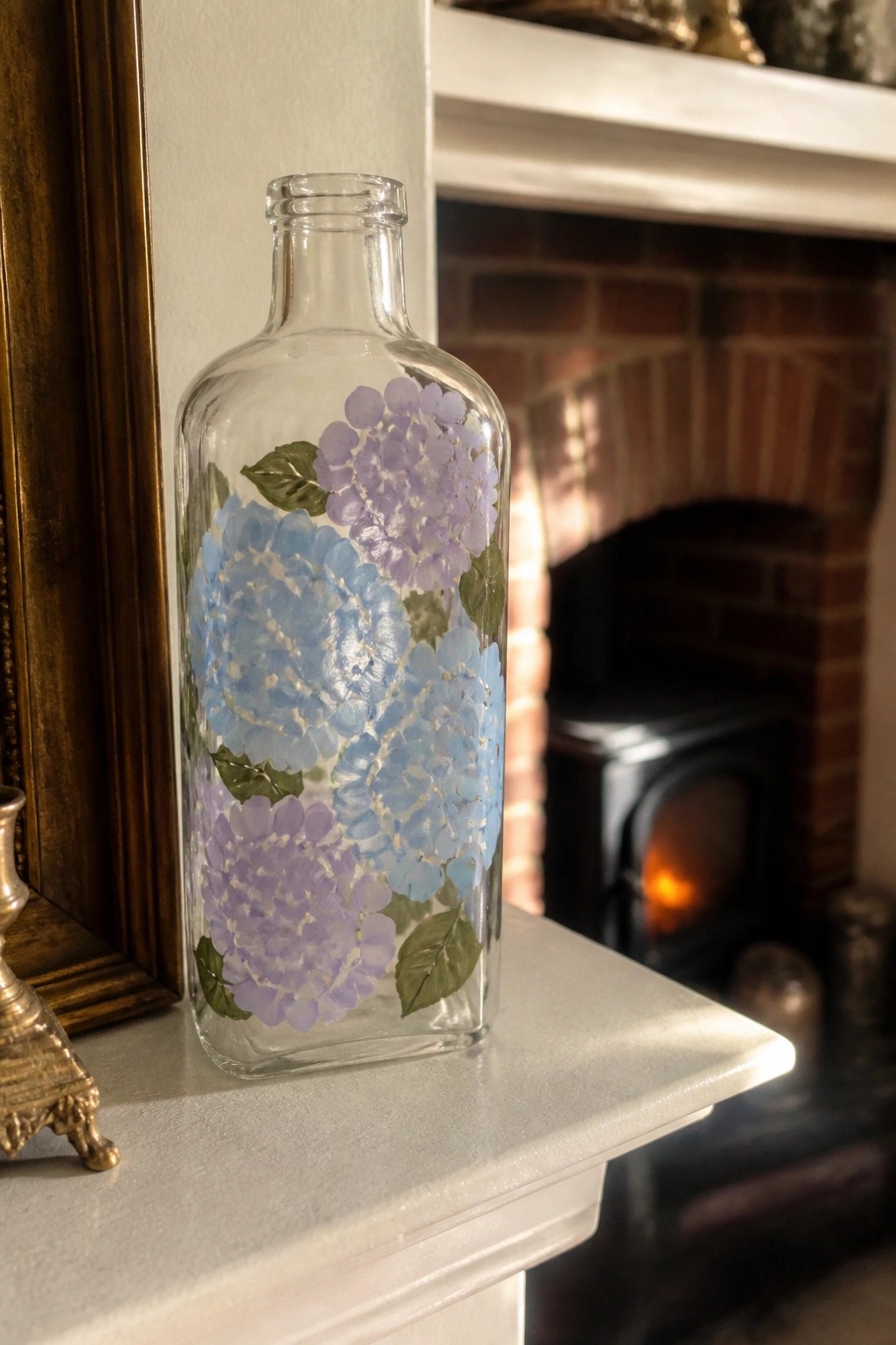 Glass bottle painted with blue and purple hydrangeas on white mantel by fireplace