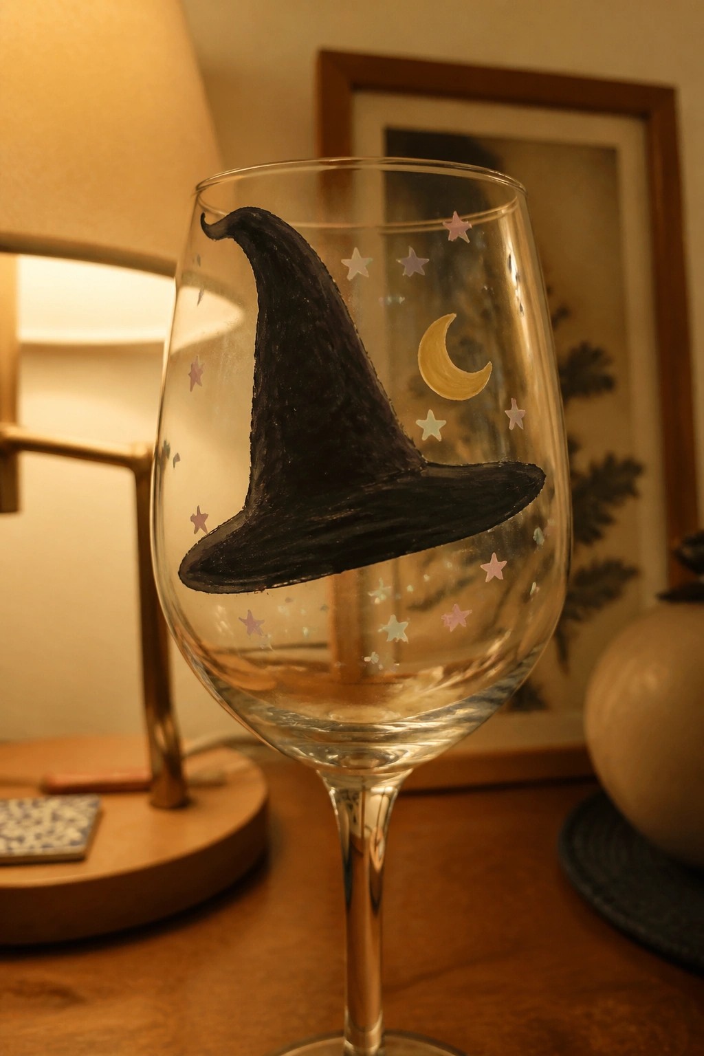 Wine glass hand-painted with black witch hat, stars, and golden crescent moon