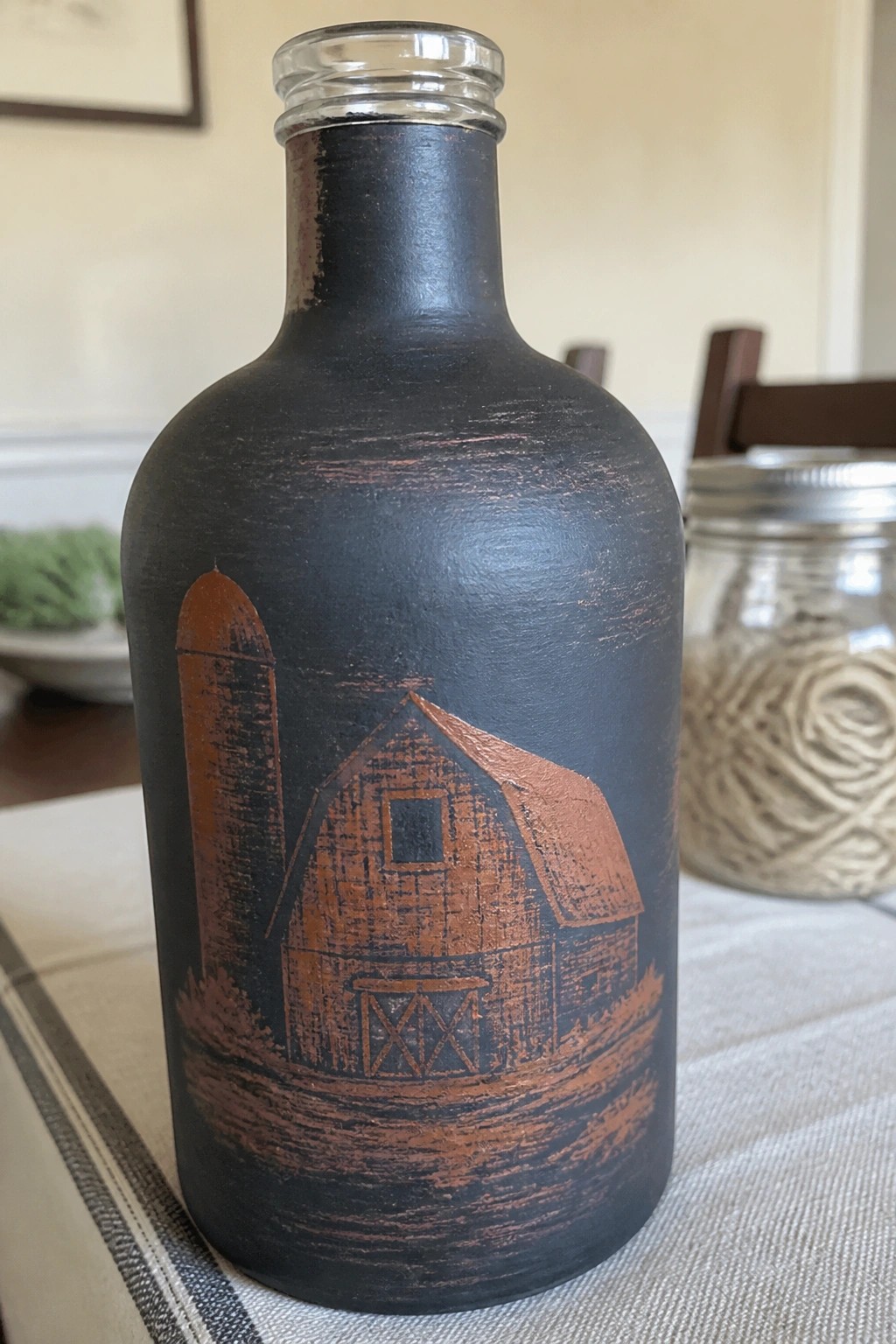 Black bottle with distressed copper barn, silo, and farm scene design