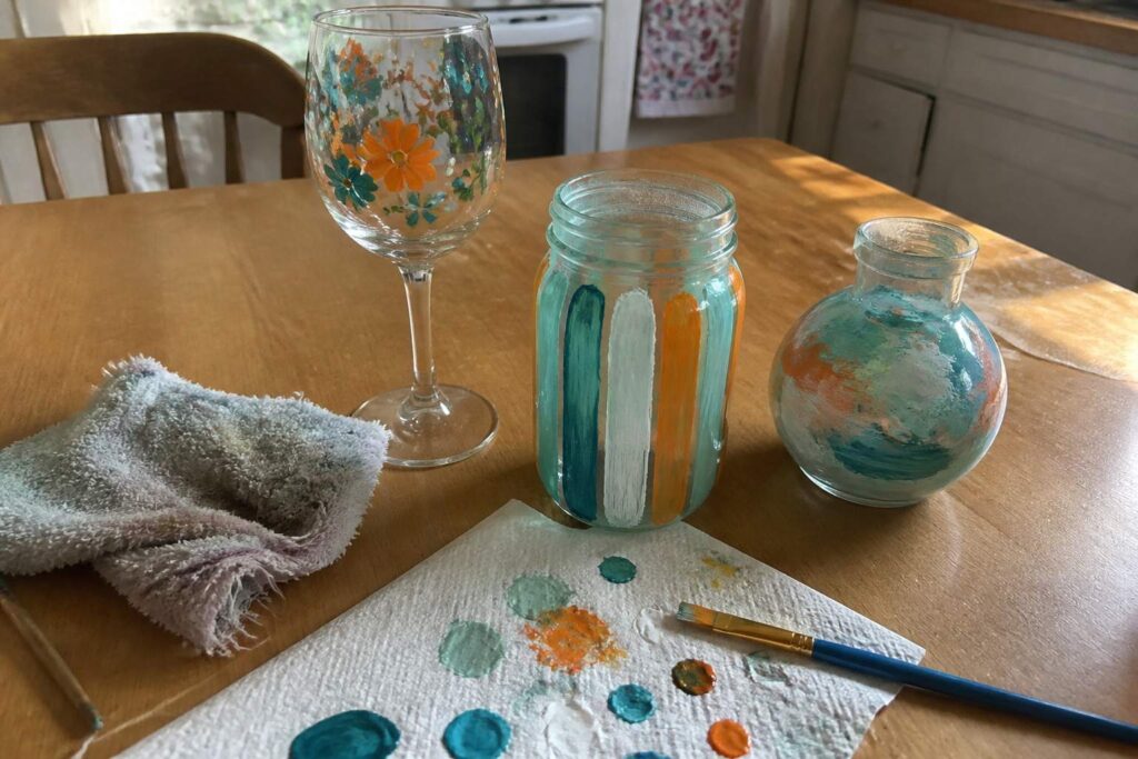 Painted glass bottles and jars on a wooden table