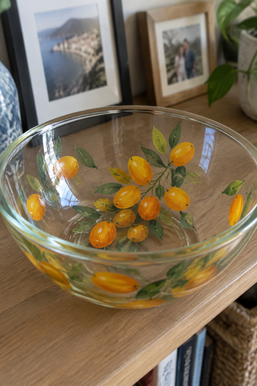 Glass bowl hand-painted with yellow fruits and green leaves on wood