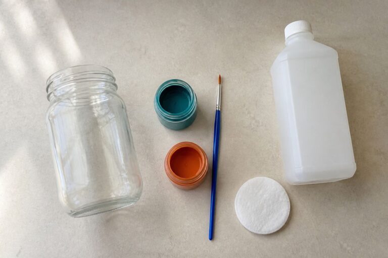 Glass enamel paints, brushes, and a clean jar on a table
